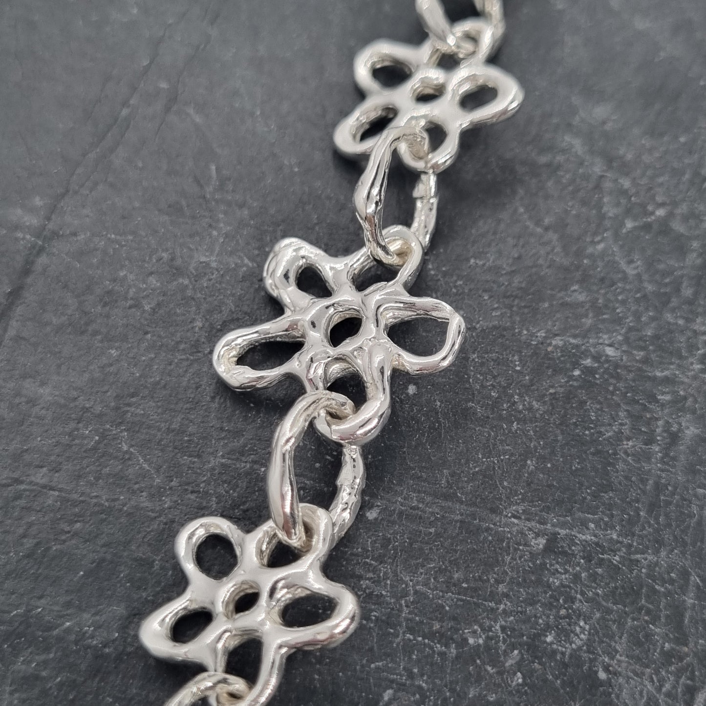 Chunky sterling silver flower chain necklace on a dark grey background