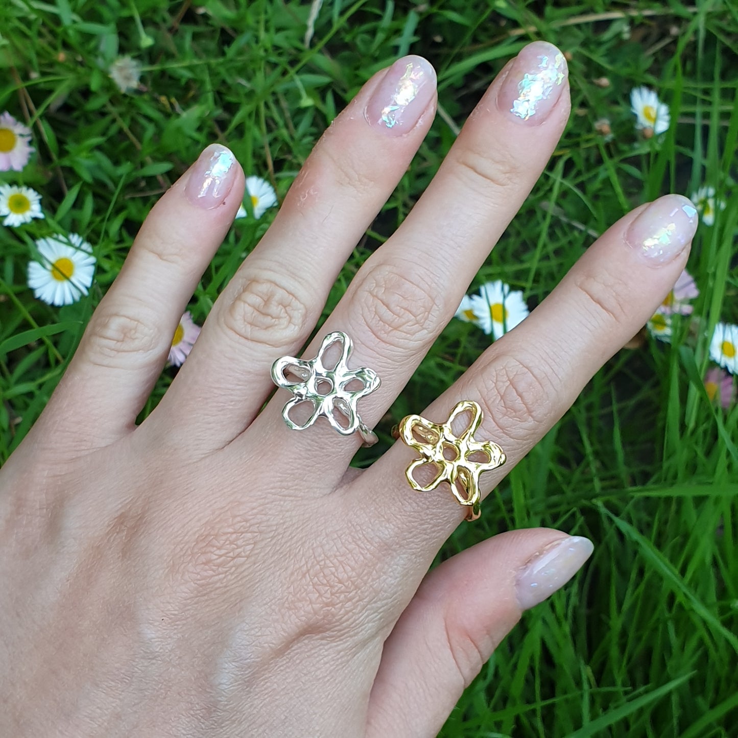 sterling silver and gold flower rings on hand