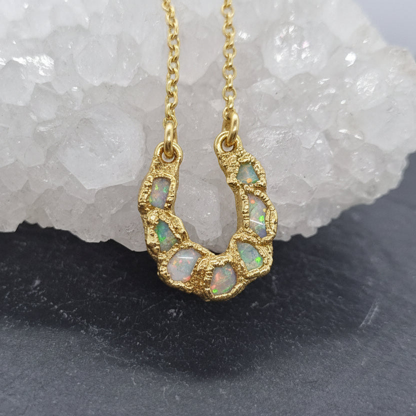 gold rustic textured necklace with a horseshoe-shaped pendant with seven freeform Australian opals set in it. Handmade by Jo Cooper Jewellery