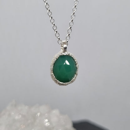 Necklace with a green pendant on a gray background