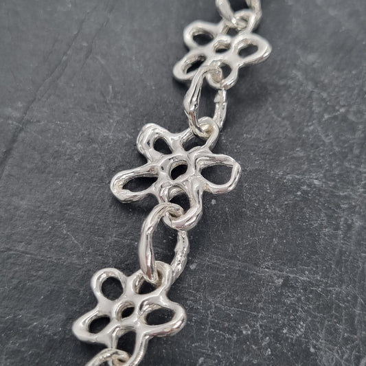 Chunky sterling silver flower chain necklace on a dark grey background