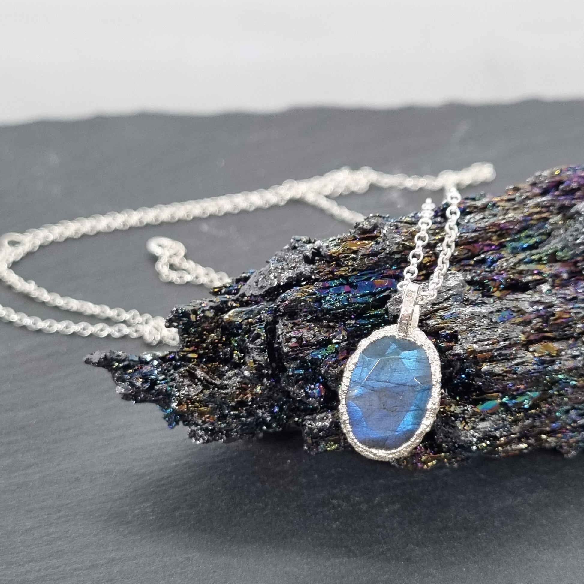 oval labradorite sterling silver pebble necklace handmade by Jo Cooper Jewellery displayed on a black crystal