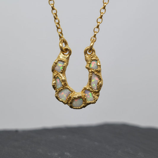 Textured gold plated sterling silver necklace with a horseshoe-shaped pendant featuring freeform Australian opals set in it. Handmade by Jo Cooper Jewellery