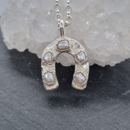 Rustic sterling silver horseshoe-shaped pendant with embedded white baroque pearls