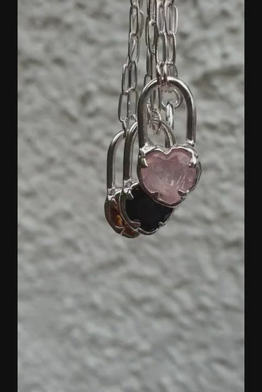 video of molten heart lock necklaces in different gemstones, citrine, rose quartz, ruby and black spinel