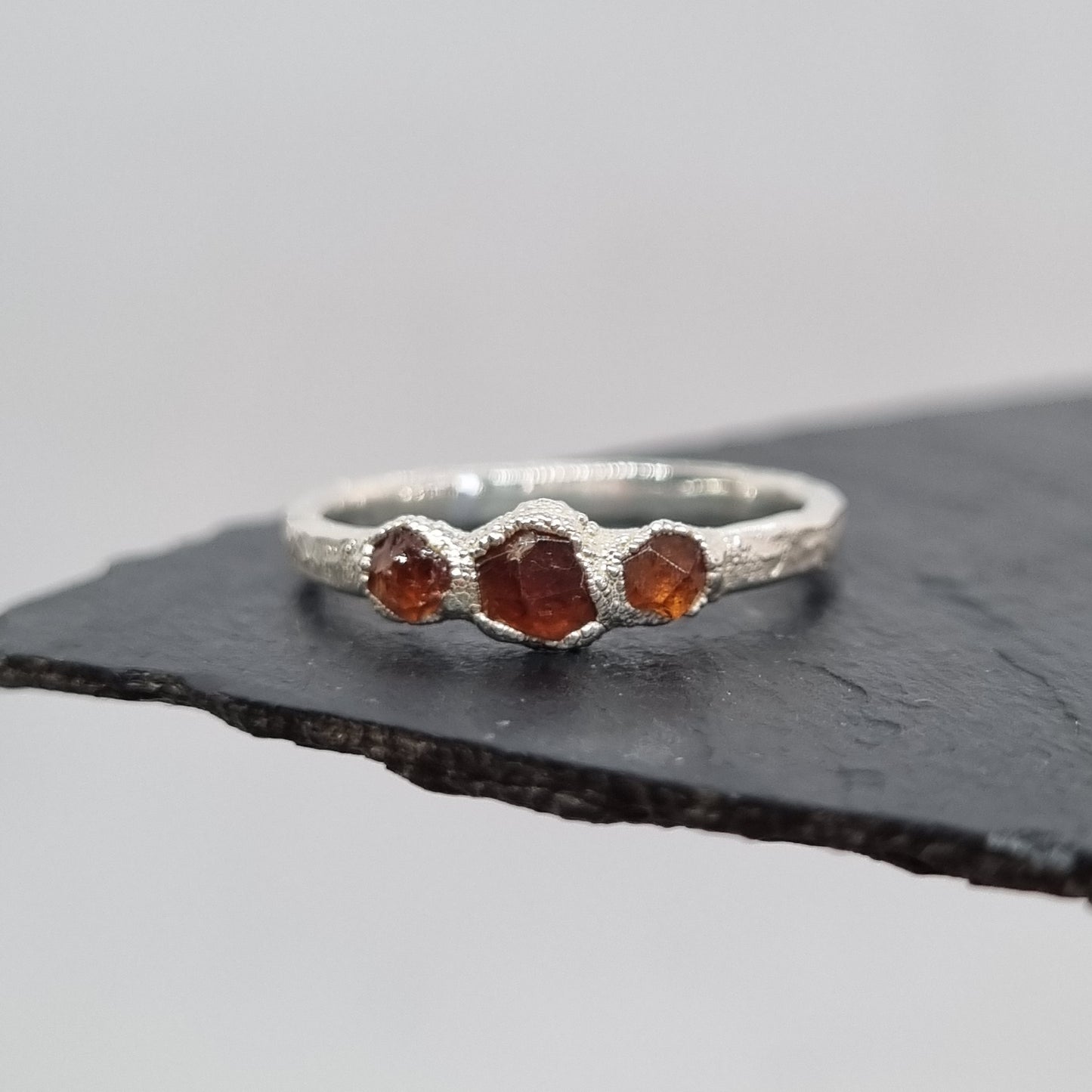 ring with three spessartite garnets set in textured silver