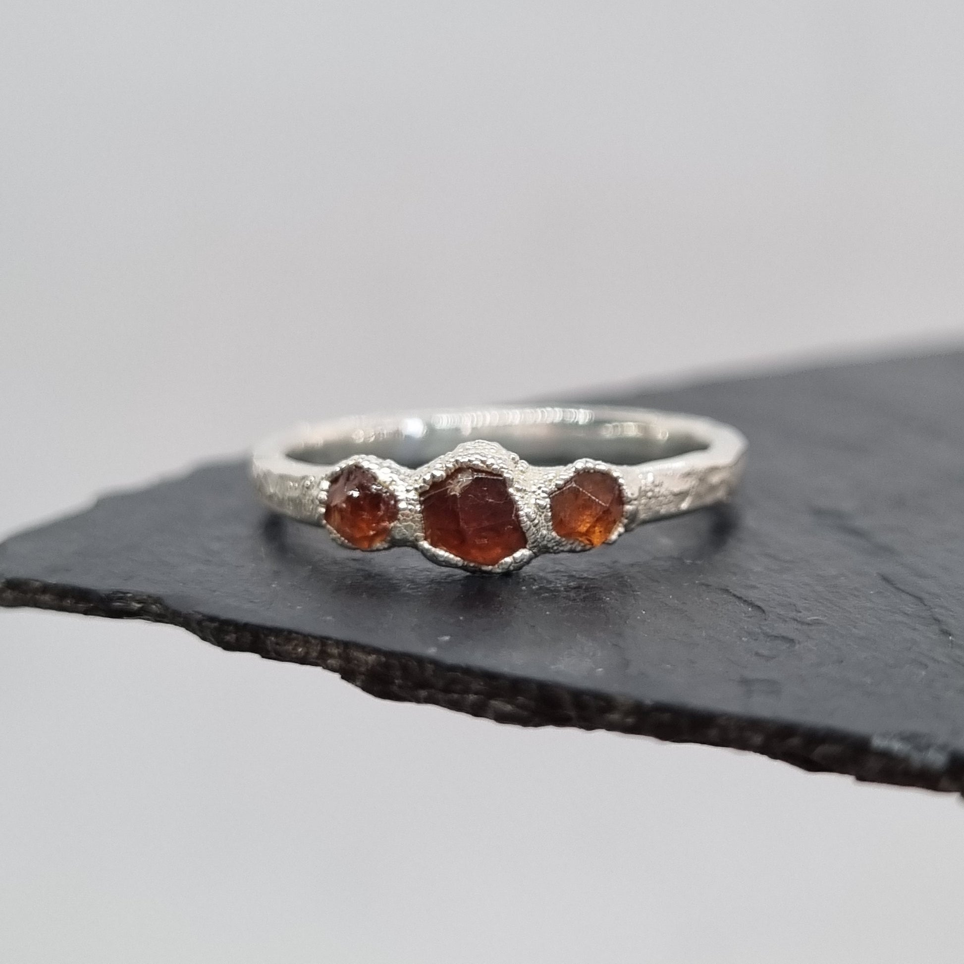 ring with three spessartite garnets set in textured silver