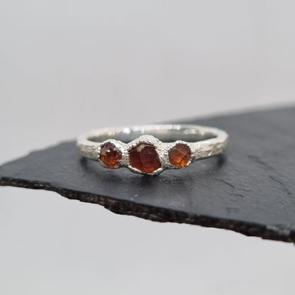 ring with three spessartite garnets set in textured silver