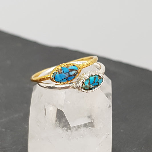 marquise Mohave turquoise raw gold and silver ring displayed on a crystal