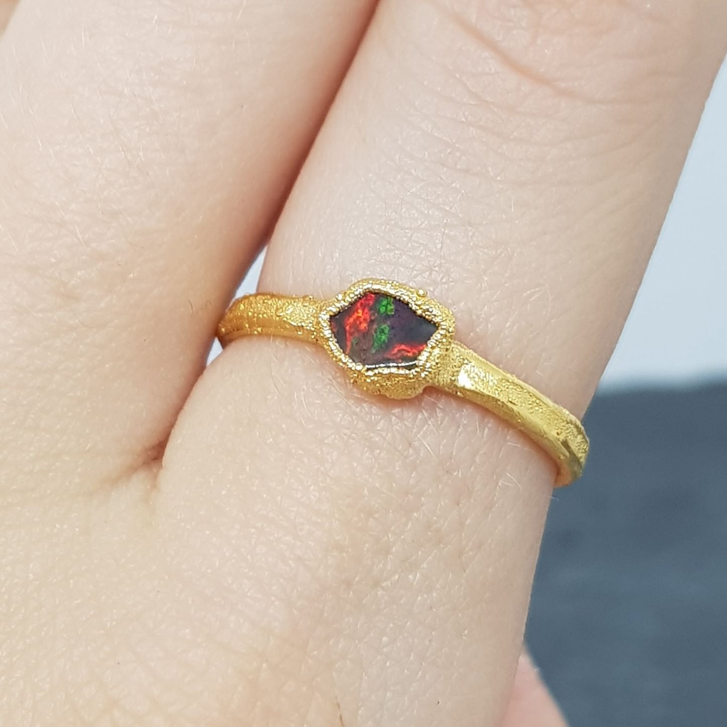 raw freeform black opal gold ring on finger