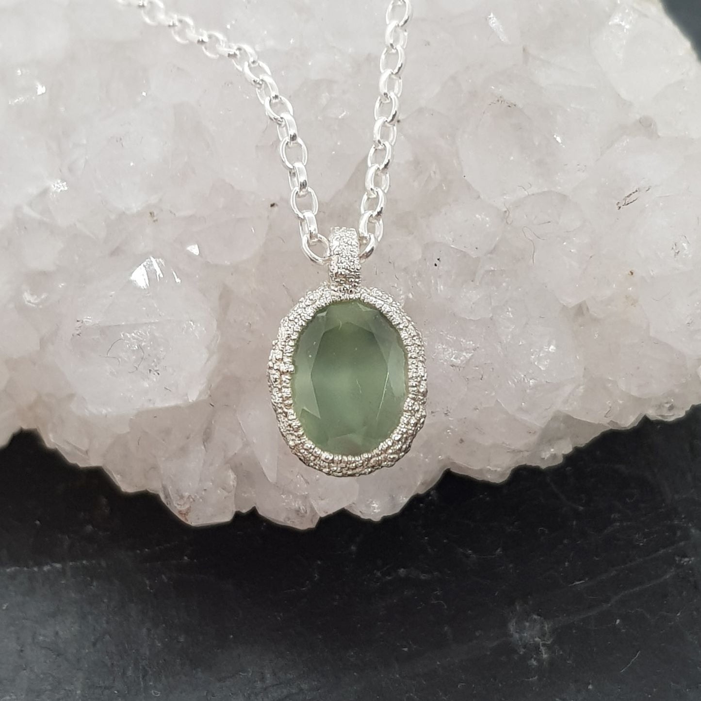 green prehnite textured silver pebble necklace displayed on a crystal