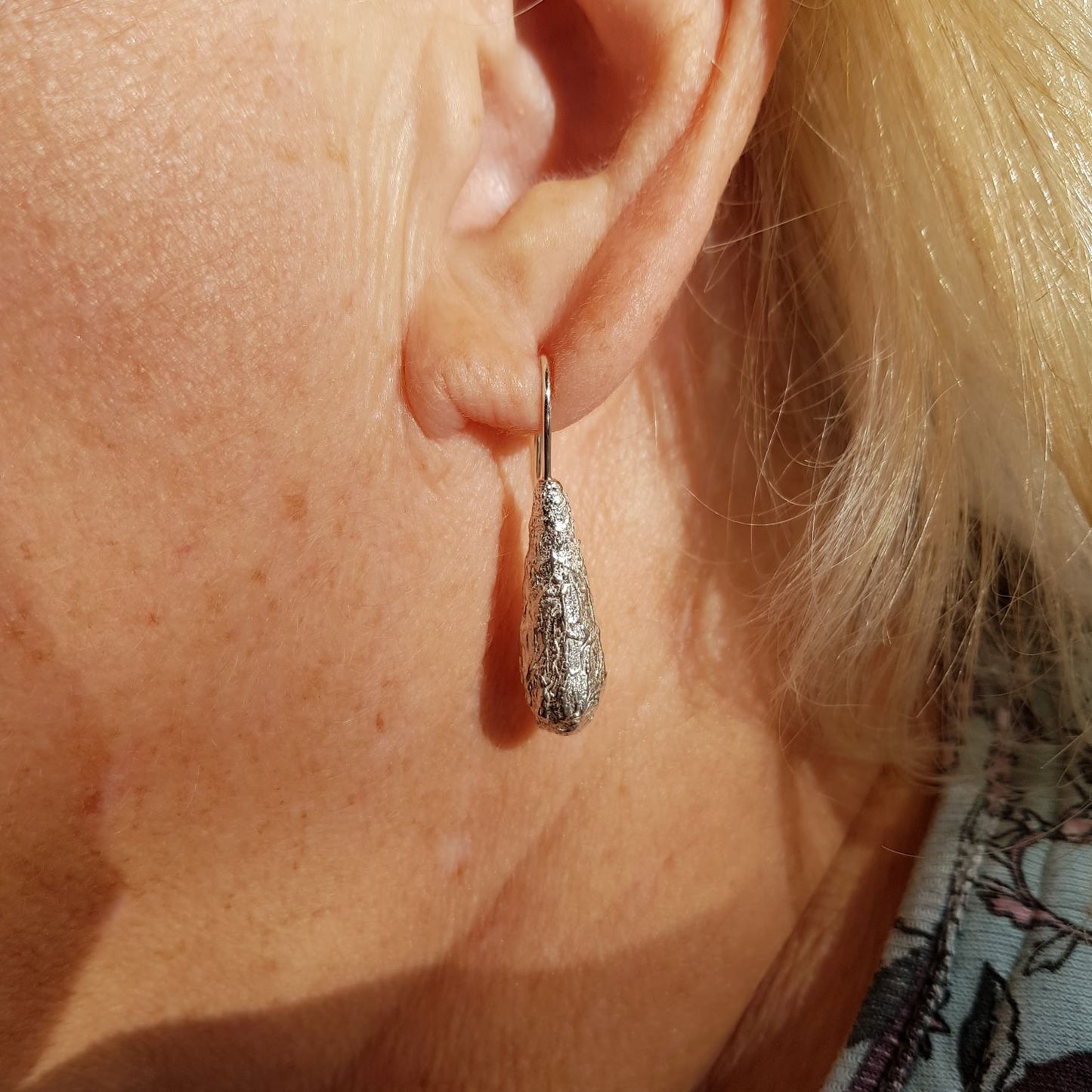 freeform textured silver long drop hook earrings on model
