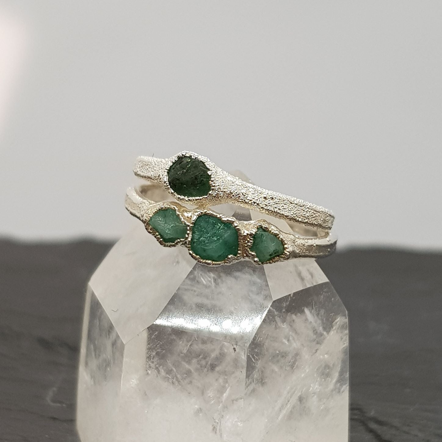 single and triple raw emerald silver rings stacked
