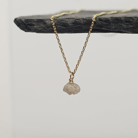 raw white diamond necklace on 9ct yellow gold chain, displayed hanging from a black slate