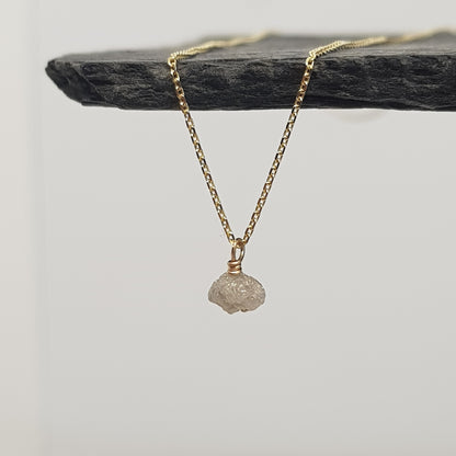 raw white diamond necklace on 9ct yellow gold chain, displayed hanging from a black slate